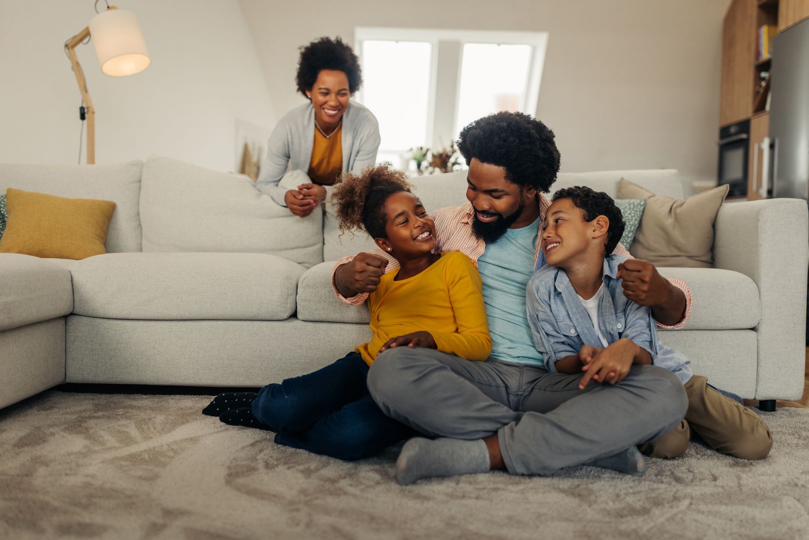 Parents and their children relaxing together on the living-room floor
