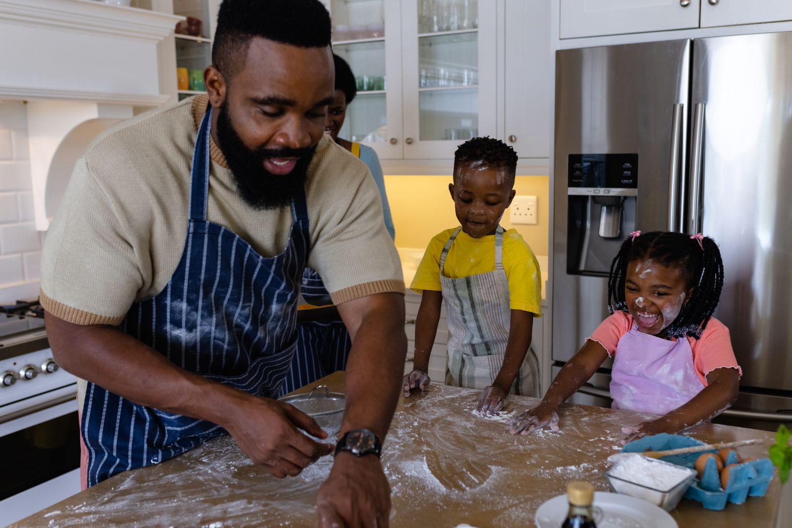A father baking with his two children in the family kitchen